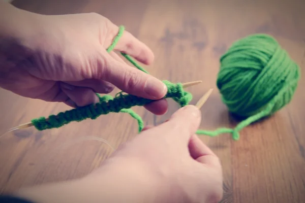 Knitting with green wool on wooden table — Stock Photo, Image