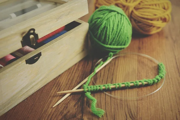 Knitting with green wool on wooden table — Stock Photo, Image