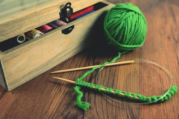 Knitting with green wool on wooden table — Stock Photo, Image