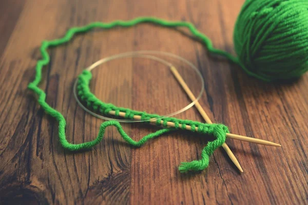 Knitting with green wool on wooden table — Stock Photo, Image