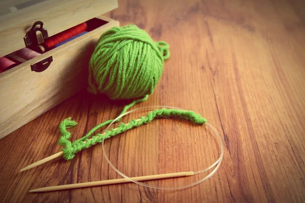 Knitting with green wool on wooden table — Stock Photo, Image