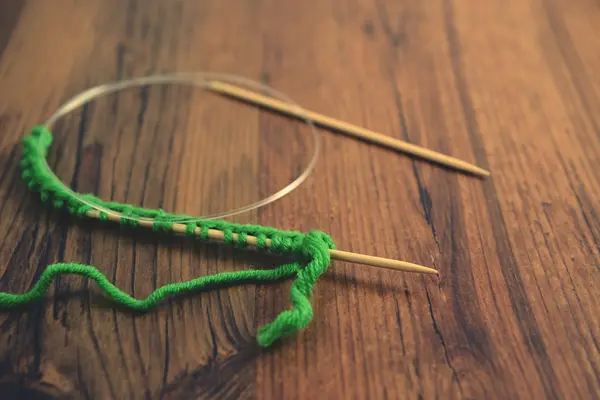 Knitting with green wool on wooden table — Stock Photo, Image