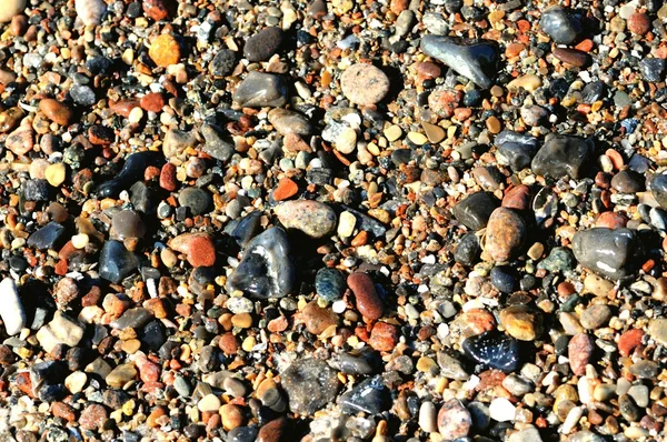 Seixos na praia de porto mais escuro nas ondas . — Fotografia de Stock