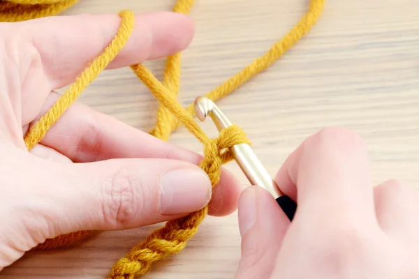 Вязание с коричневой шерстью в руке . — стоковое фото