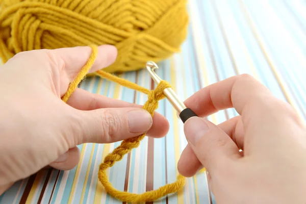 Crocheting with brown wool in hand. — Stock Photo, Image