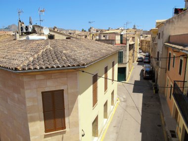 Alcudia, Mallorca / İspanya 16 Haziran 2015: boyunca tarihi kent Alcudia (Mallorca, İspanya) kısmında otopark arabalar. Eski kasaba bölümünün tipik evleri.
