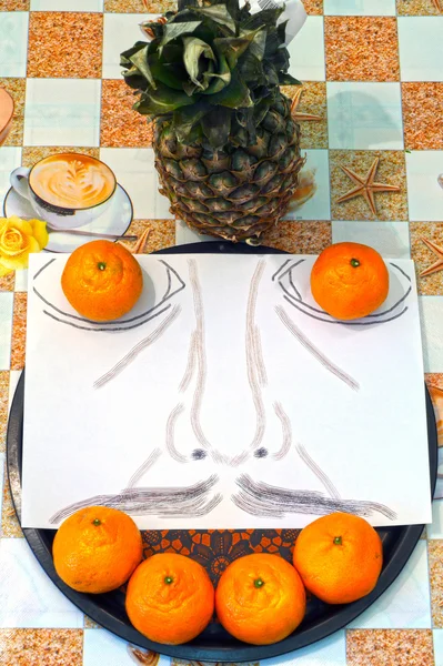 Bir adamın bıyıklı, güler yüz mandarin ve ananas tabağa konmuş.