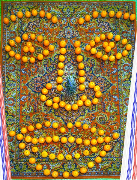 Mandarin ve ananas bir halı üzerinde bir adamın gülümseyen yüzünü düzenlendiği.