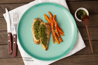 Izgara tavuk göğsü, yeşil bir tabakta bitki ve havuç..