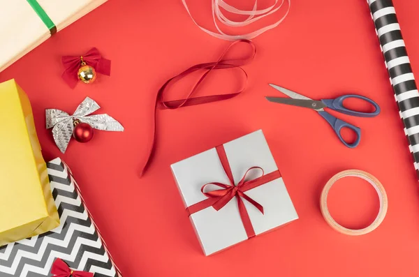 Caixas Presente Papel Tesoura Fita Bolas Natal Sobre Fundo Vermelho — Fotografia de Stock