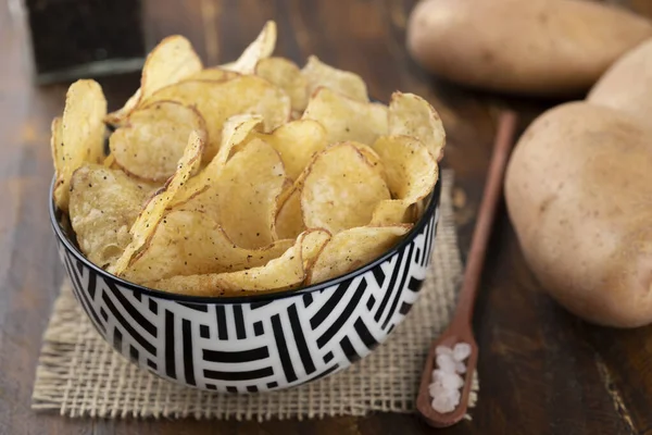 Schüssel Voller Kartoffelchips Mit Rohen Kartoffeln Und Einem Löffel Salz — Stockfoto