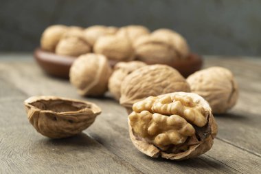 Cevizler ahşap bir masanın üzerinde ve bir tabağın üzerinde.