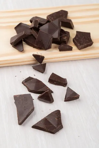 Einige Dunkle Schokoladenstücke Auf Einem Holzbrett — Stockfoto