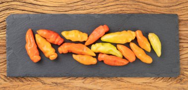 Tahta bir masanın üzerinde portakallı cheiro biberler. Tipik Brezilya malzemesi..