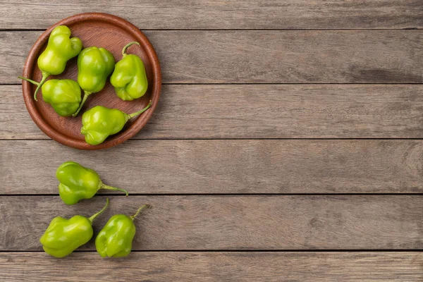 Pimentos Cambuci Verdes Uma Placa Sobre Mesa Madeira Com Espaço — Fotografia de Stock