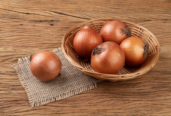 Zwiebeln Korb Über Holztisch — Stockfoto