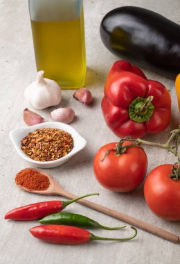 Domates, dolma biber, zeytinyağı, patlıcan ve ahşap masa üzerinde sarımsak. Akdeniz yemekleri.