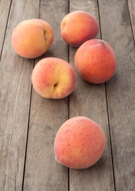 Tahta masanın üzerinde bir grup şeftali..