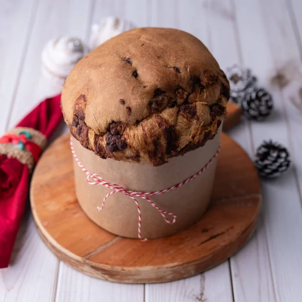 Chocotone, geleneksel İtalyan pastası panettone üzerinde çikolata parçacıkları olan ahşap masa.