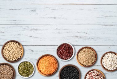 Kopya alanı olan ahşap masa üzerinde çeşitli fasulyeler..