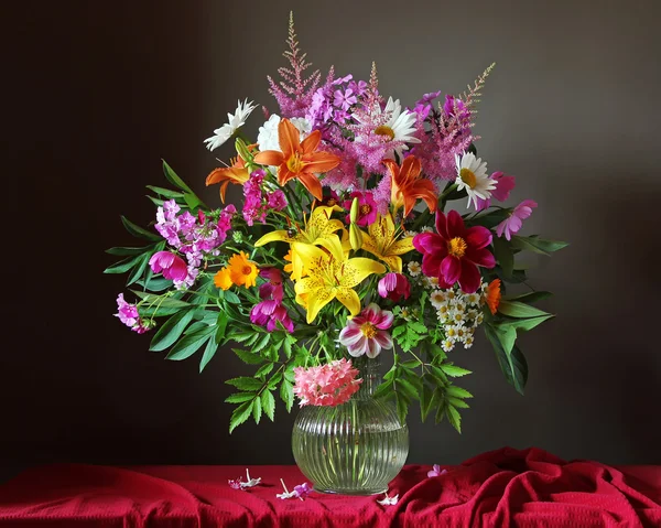 Beautiful bouquet of garden flowers in glass jug — Stock Photo, Image