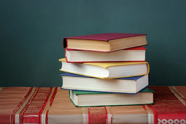 A stack of books on the table with a red tablecloth. — Stock Photo, Image