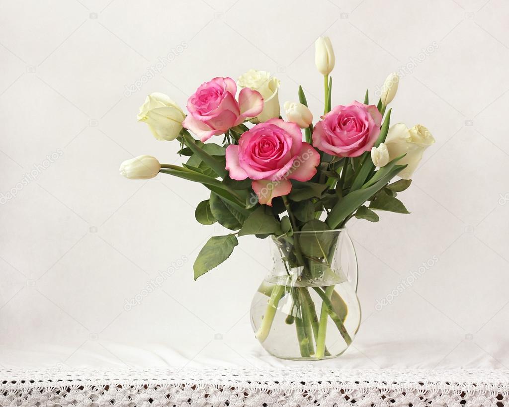 Bouquet with roses and tulips in a transparent jug
