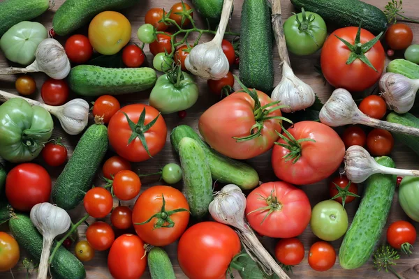 Verse komkommers, tomaten en knoflook, bovenaanzicht. Donker en humeurig. — Stockfoto