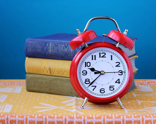 Ainda vida relógio de alarme retro vermelho e três livros — Fotografia de Stock