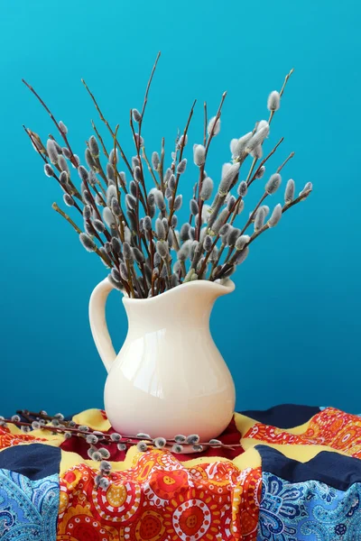 Still life with a bouquet of willow branches in a white jug. Stock Photo