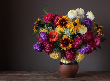 Still life with chrysanthemums and asters in a clay jug