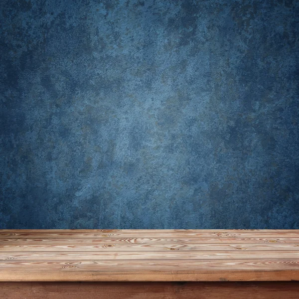 Leerer Holztisch vor blauer Wand — Stockfoto