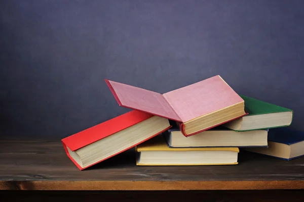 Een stapel boeken op tafel. Een open boek. — Stockfoto