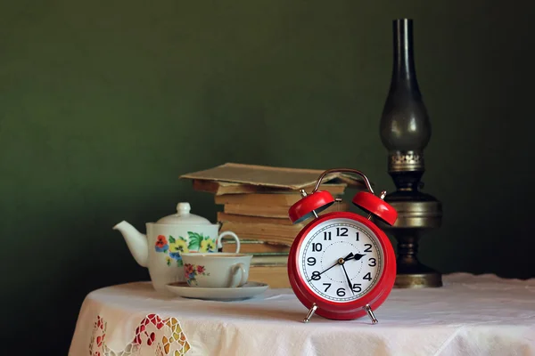 Reloj despertador retro rojo en la mesa con mantel blanco — Foto de Stock