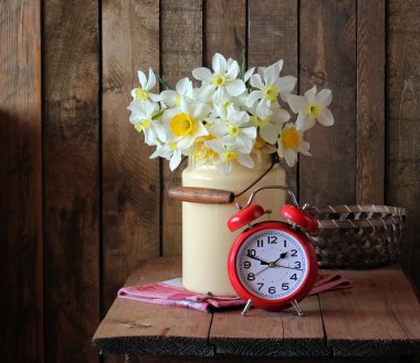 Natürmort nergis ve kırmızı bir çalar saat bir buket.