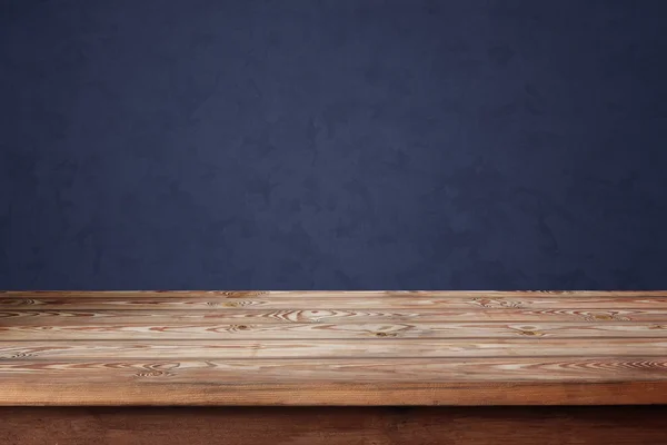 Prázdný dřevěný stůl u modré stěny. — Stock fotografie