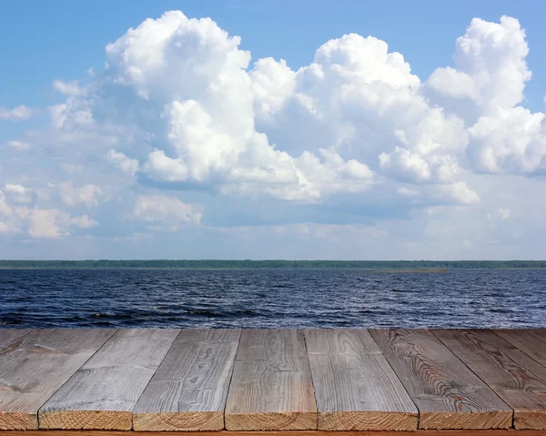 Convés de madeira vazio no fundo do mar e do céu com nuvens . — Fotografia de Stock