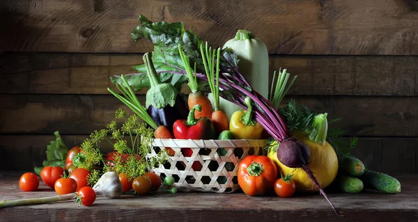 Verduras frescas en canasta sobre mesa, naturaleza muerta en estilo rústico . —  Fotos de Stock