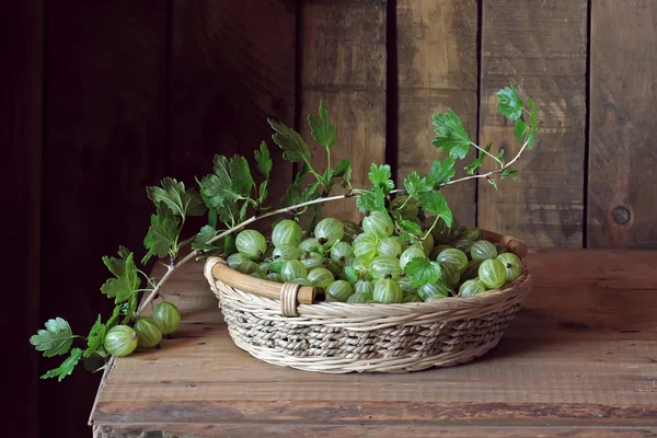 Green gooseberries in a basket on the table. — Stock Photo, Image