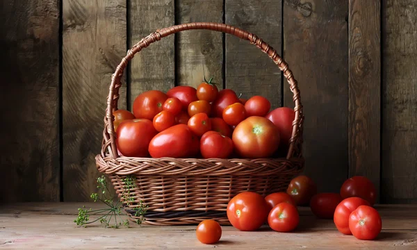 Dojrzałe pomidory w kosz na tabela, nadal życia w stylu rustykalnym. — Zdjęcie stockowe