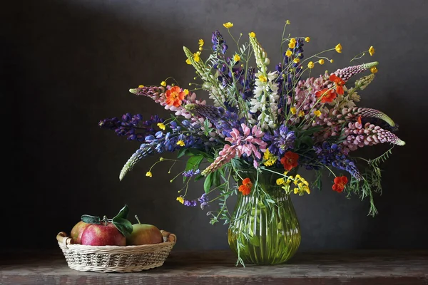 Zátiší kytice s lupine a blatouchy v skleněná váza. — Stock fotografie