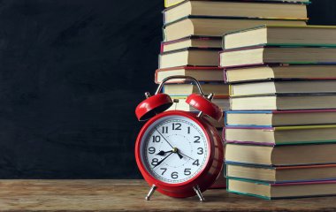 Kitapları ve okul yönetimi arka plan üzerinde çalar saat.