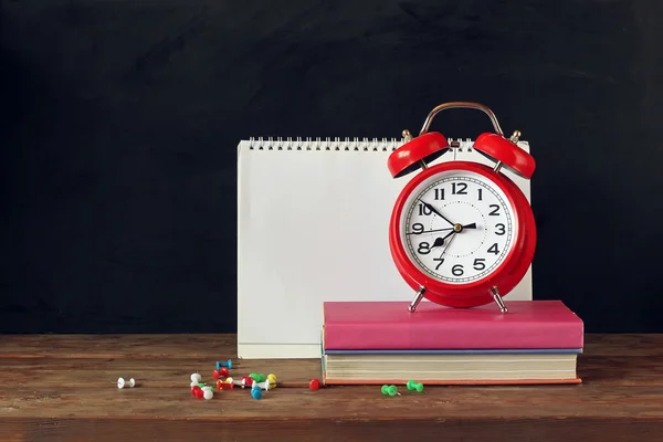 De volta à escola. Relógio despertador, livros e álbum na mesa . — Fotografia de Stock