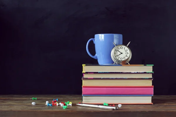 学校に戻る本、カップ、テーブルの上の目覚まし時計. — ストック写真