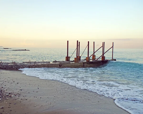 Playa de la mañana, el rompeolas al amanecer . — Foto de Stock