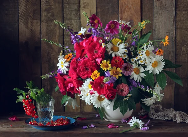 Натюрморт с букетом садовых цветов и красной смородины . — стоковое фото