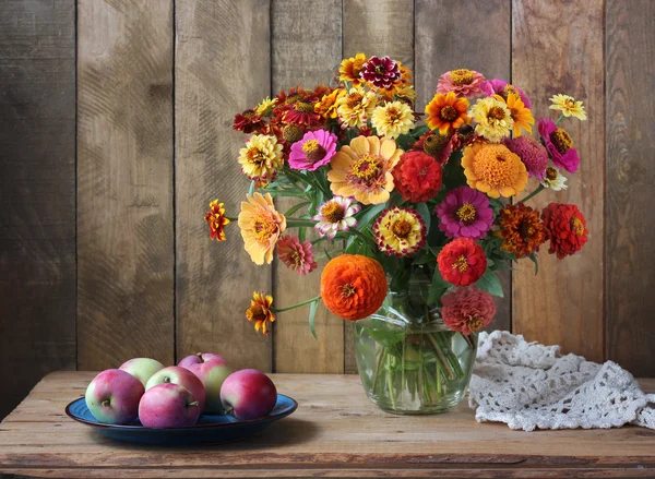 Still life with a bouquet and apples. — Stock Photo, Image