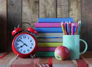 Çalar saat, kalem ve kitap yığını. Okula dönüş. 