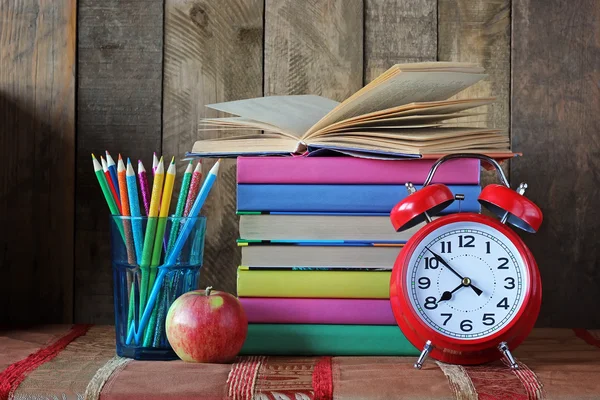 Alarm klok, potloden en een stapel boeken. Terug naar school. — Stockfoto