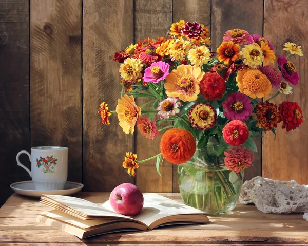 Ramo de flores de jardín, una manzana y un libro . — Foto de Stock